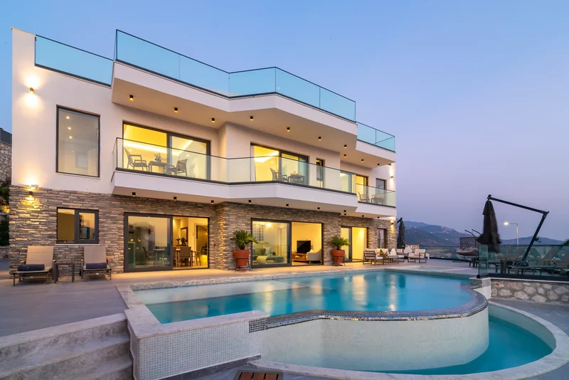 A house in Kalkan with an illuminated pool terrace at dusk